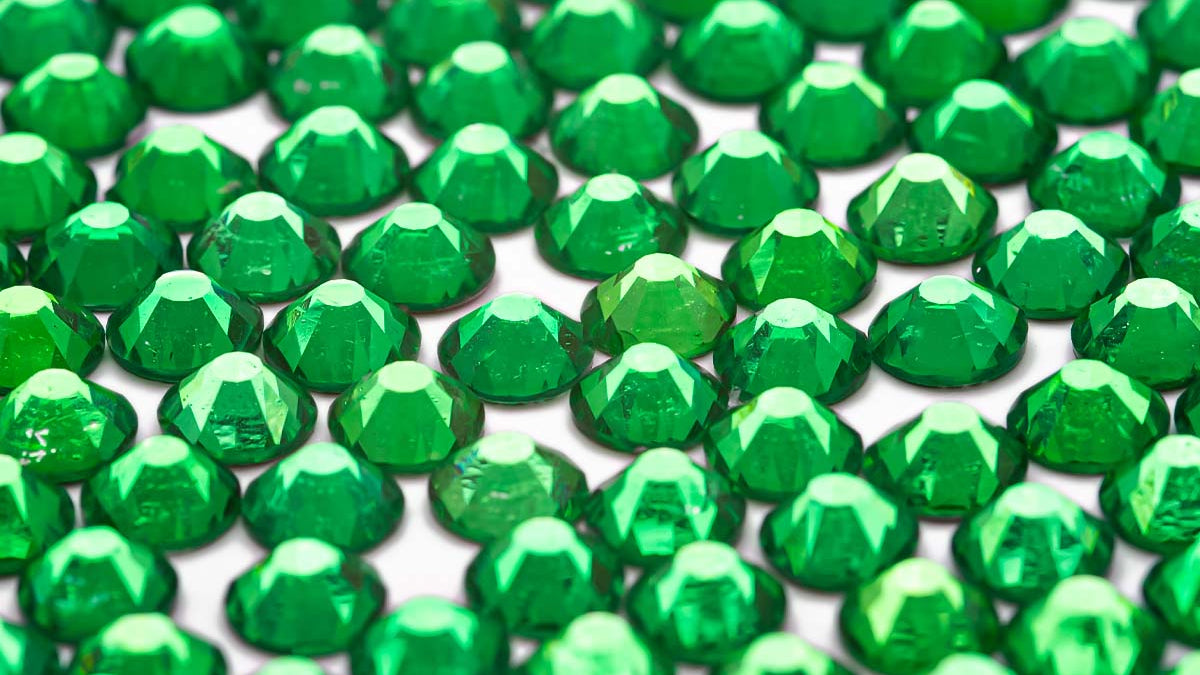 A close-up image of multiple jade green gemstones arranged in a pattern.