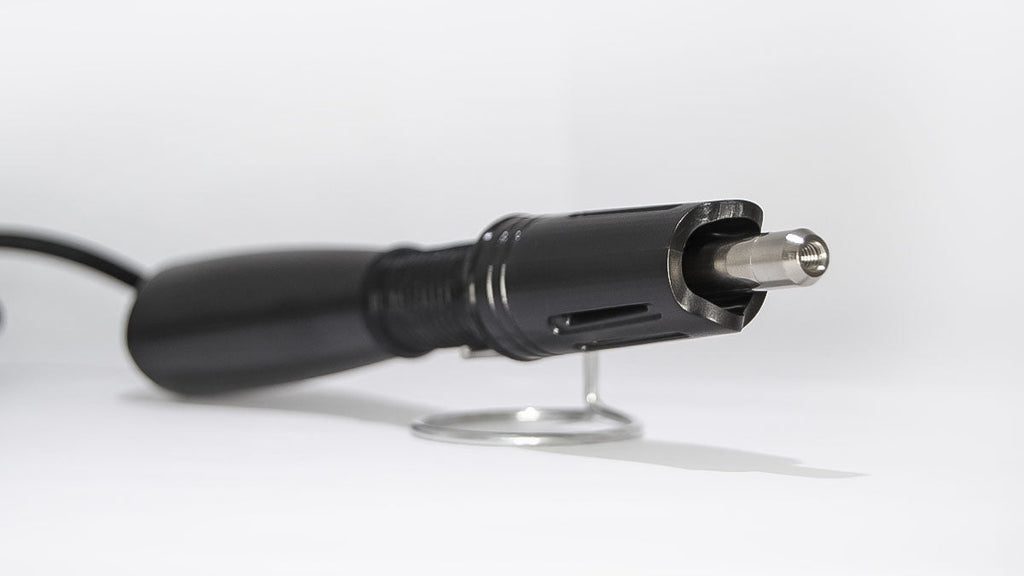 A black hotfix rhinestone applicator with a metallic tip is displayed on a stand against a white background.